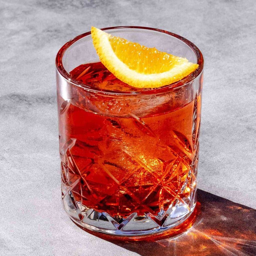 a glass of Mezcal negroni with a slice of orange on top