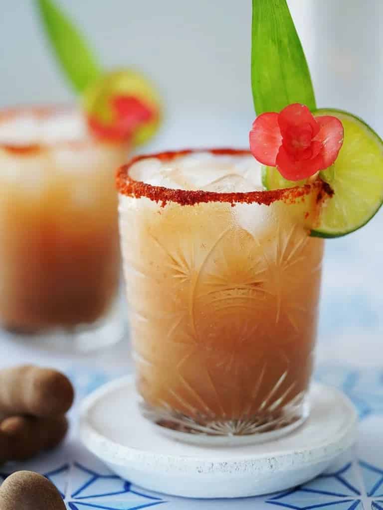 a glass of fresh chilled tamarind cocktail served with fresh lemon slice