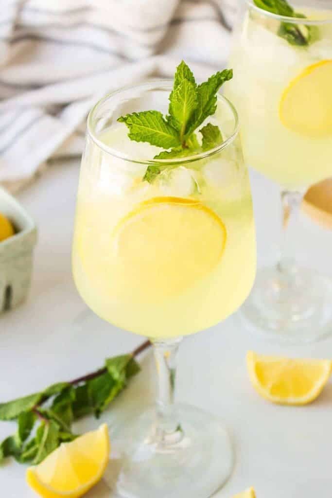 a glass of limnocello along with lemon and fresh mint leaves