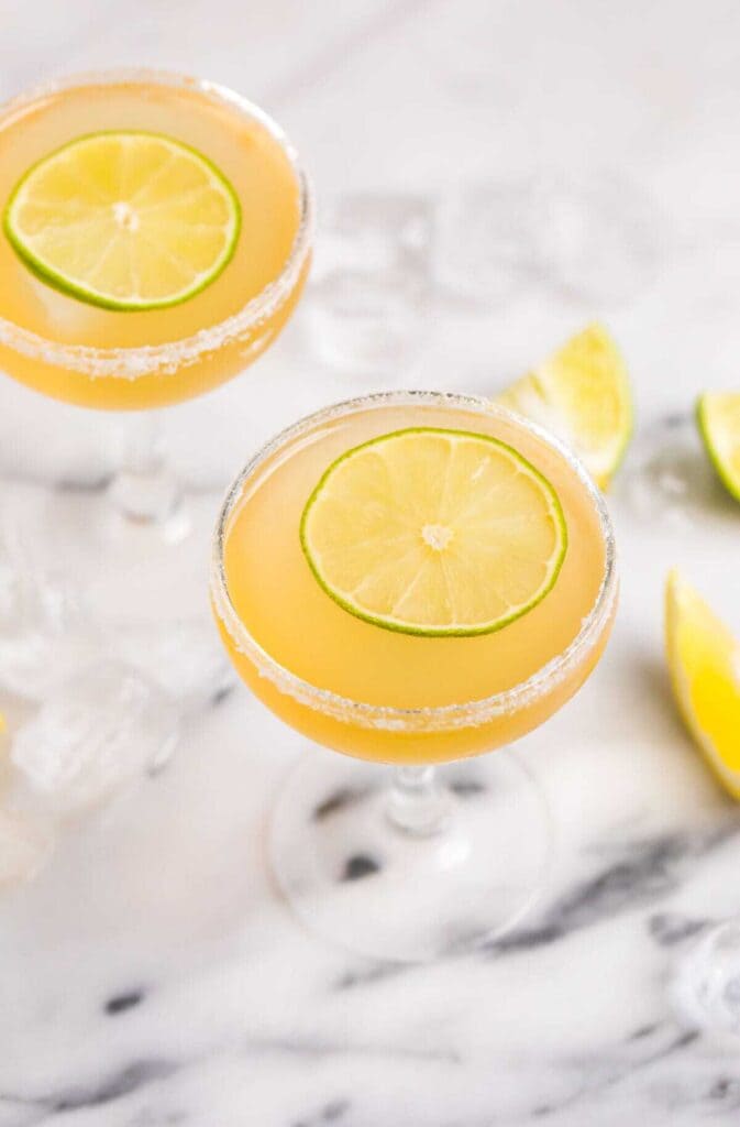 a glass of margarita italiana along with fresh lemon slices on top