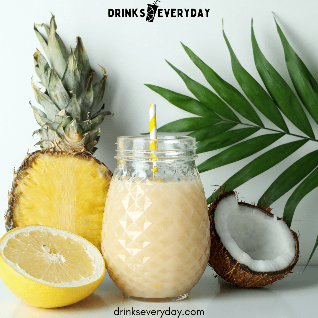 a jar of juice along with pineapple lemon and coconut