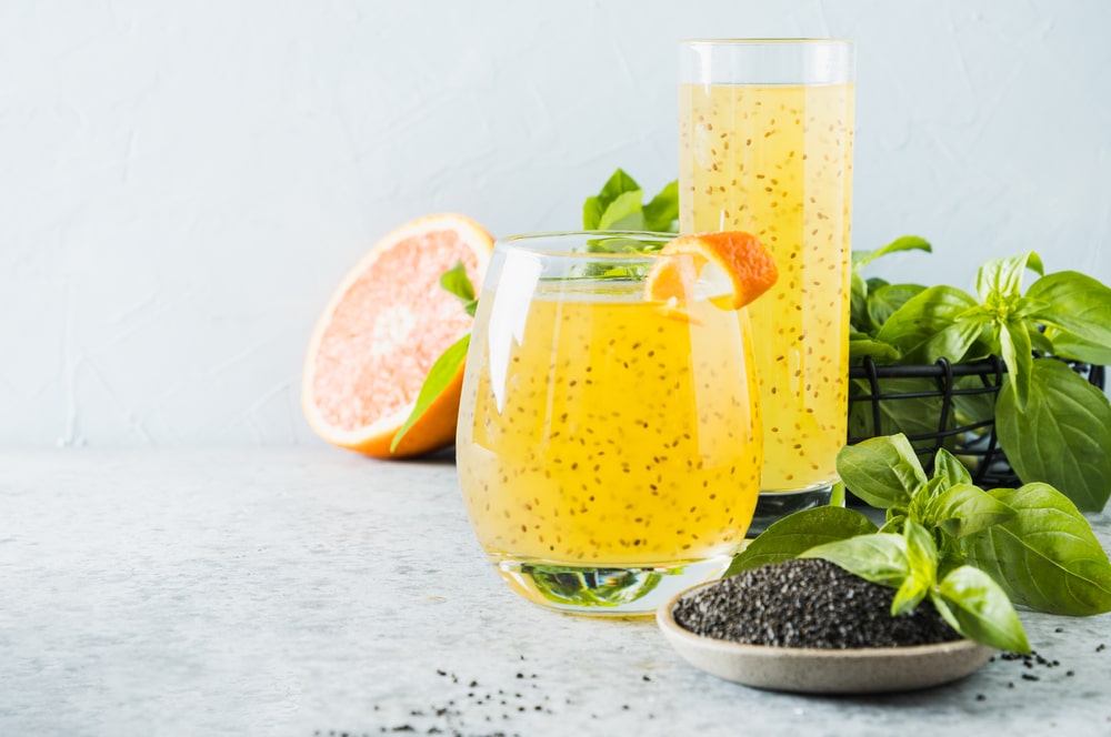 basil seed drink in glasses along with basil leaves and seeds