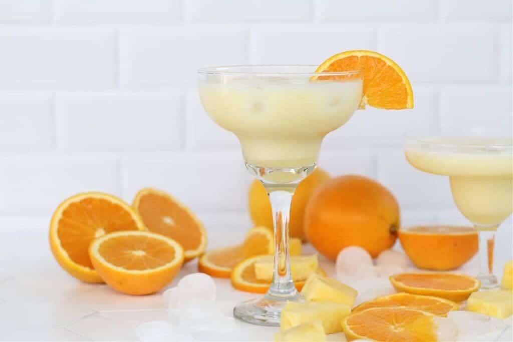 orange coconut crush along with ice cubes and oranges on the slab