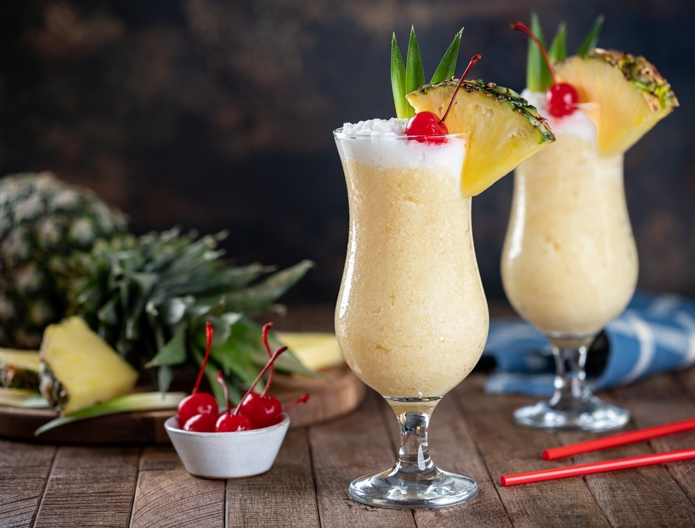 Pina Colada Cocktail Garnished With Cherry Pineapple Slice And Leaves