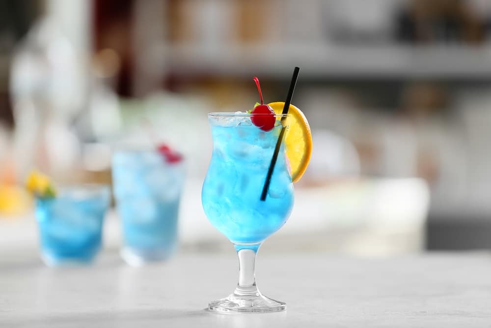 Glasses Of Blue Lagoon Cocktail On Table In Room