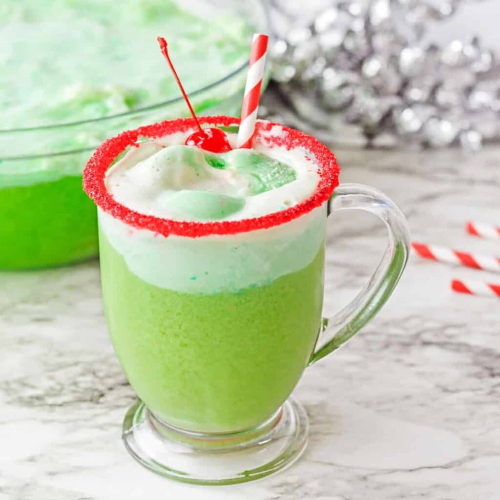 Creamy Grinch Delight served in a cup topped with cream and cherry