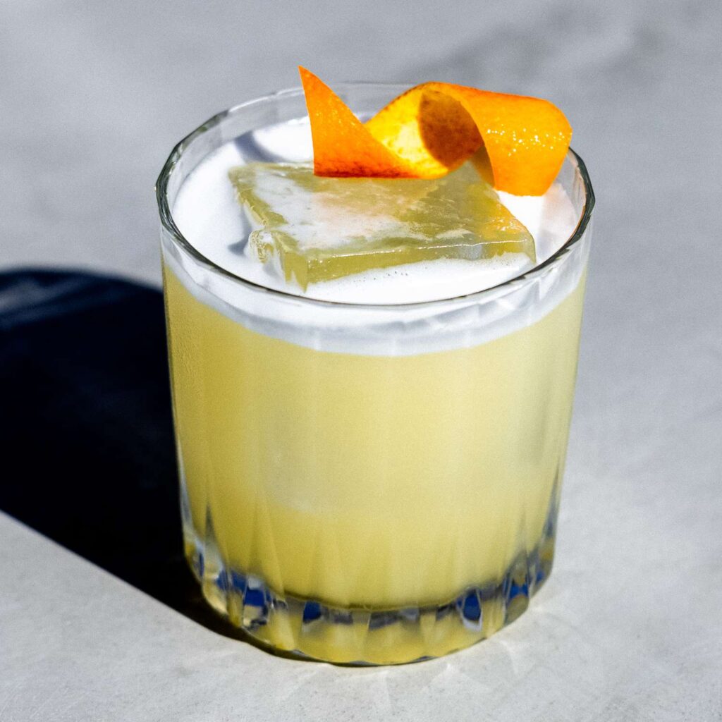 scotch sour i a glass garnished with orange zest