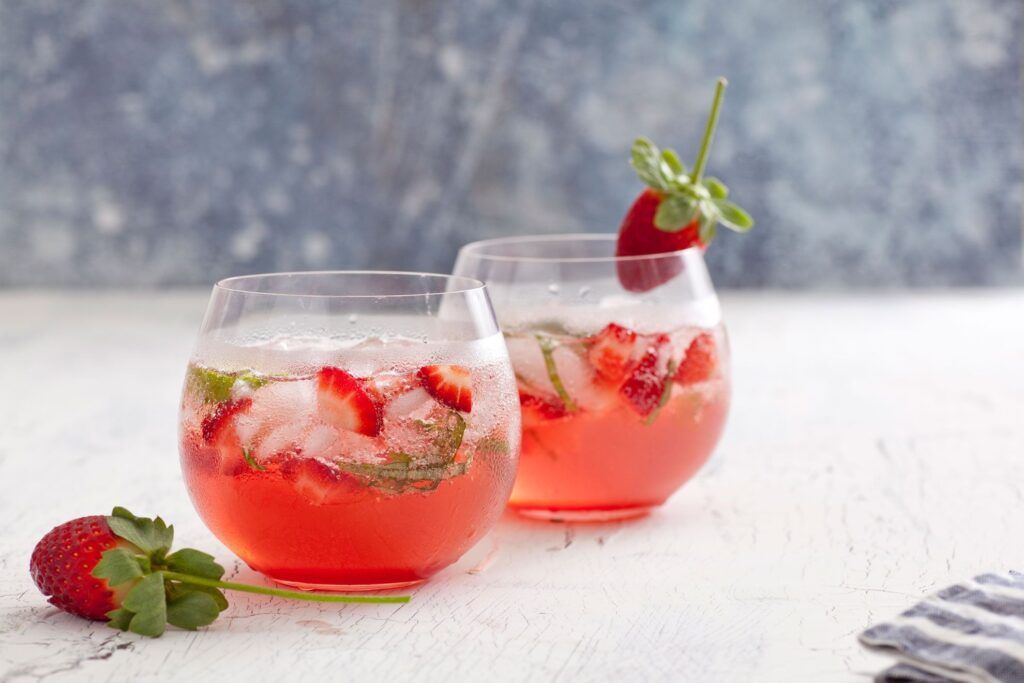 two glass of Strawberry Gin Tonic garnished with strawberry chunks