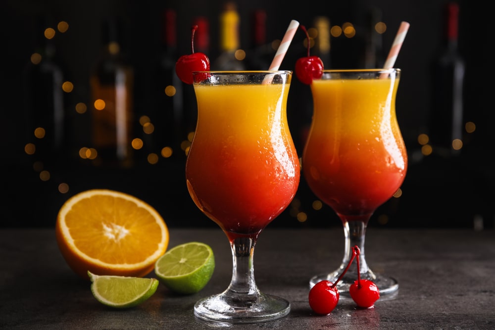 Fresh alcoholic Tequila Sunrise cocktails on grey table