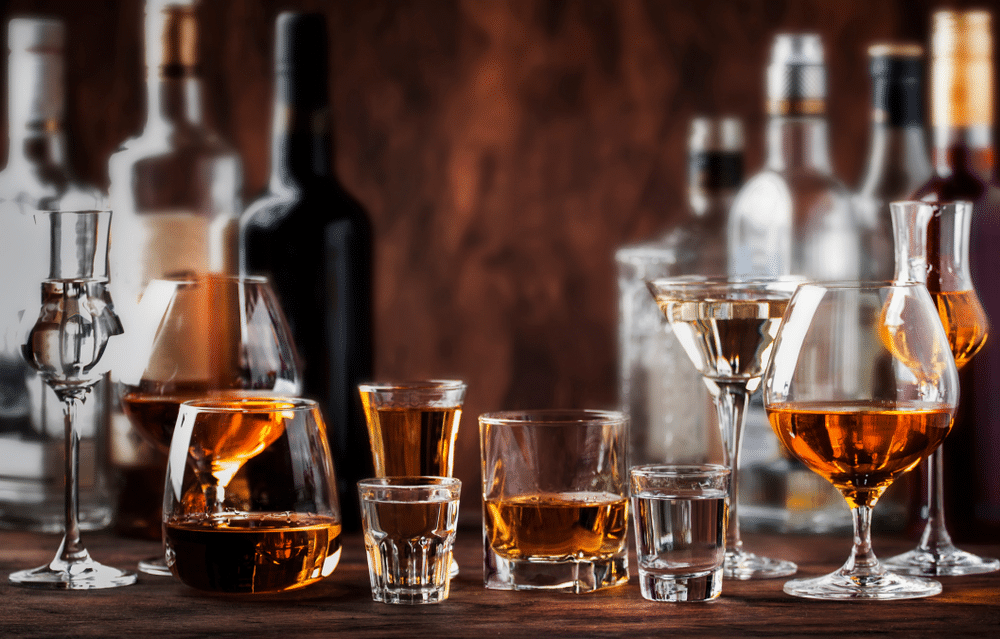 Strong alcohol drinks hard liquors spirits and distillates iset in glasses and bottles