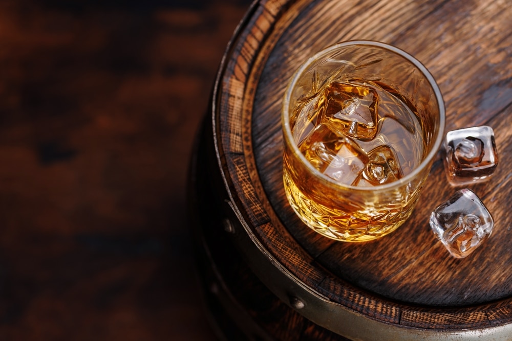 Whiskey Glass With Ice On A Rustic Barrel A Classic