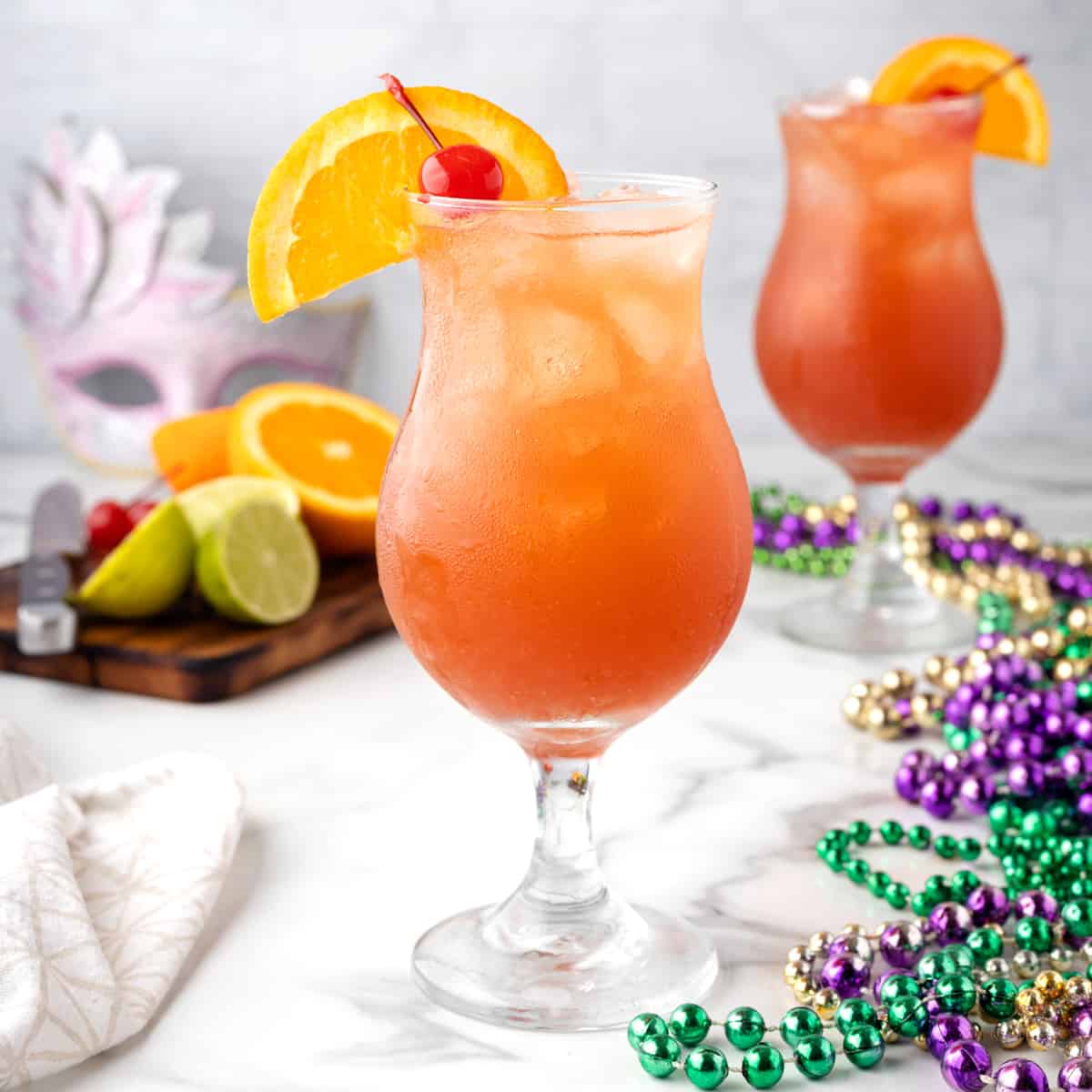 A view of a glass of hurricane drink with cherry and orange as garnish