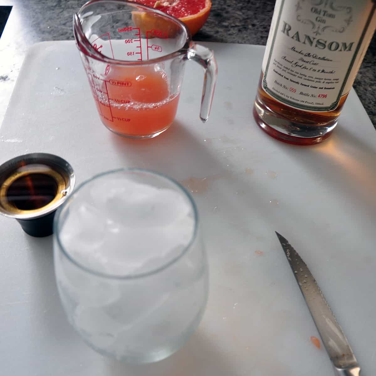 A view of ice in a glass with ingredients of greyhound drink