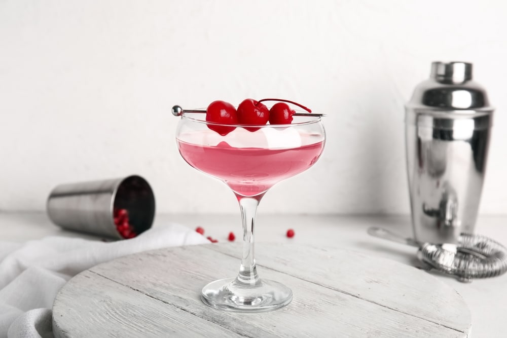 A view of a glass of Cosmopolitan cocktail with cherries on top